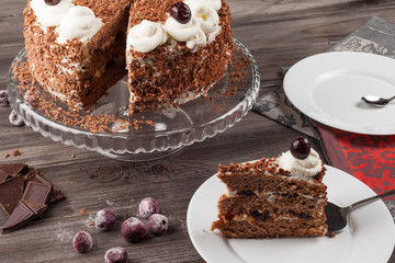 Black forest cake decorated with whipped cream and cherries. 