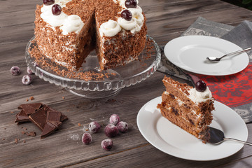 Black forest cake decorated with whipped cream and cherries. 