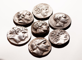 Ancient greek silver coins on reflective surface