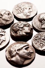 Silver coins of ancient Greece on reflective surface
