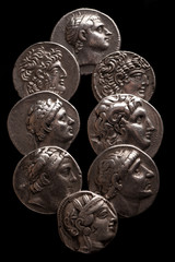 Collection of ancient greek coins on a black background