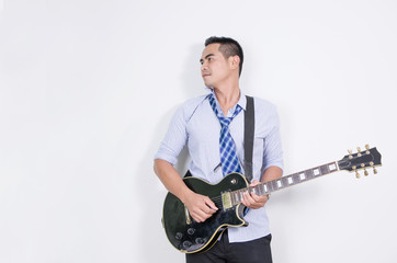 Relaxing asian business man playing electric guitar near the whi