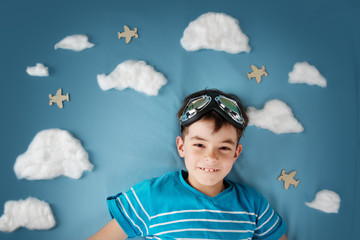 boy lying on blanket with white clouds