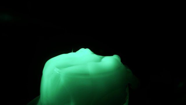 Light Green Mist Comes Out of Glass Vessel on a Background of Total Darkness