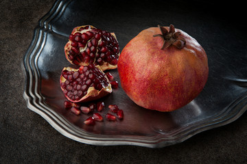 Pomegranate with seeds on the metal plate