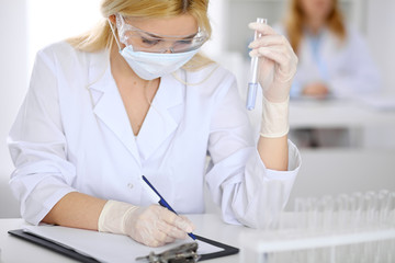 Female scientific research team with clear solution in laboratory