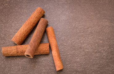 Cinnamon sticks on light brown background
