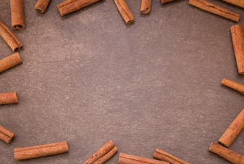 Cinnamon sticks on light brown background