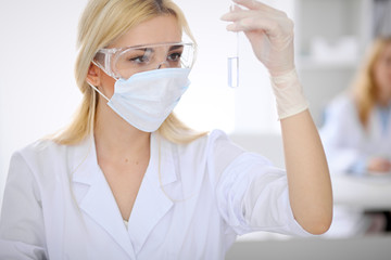 Female scientific research team with clear solution in laboratory