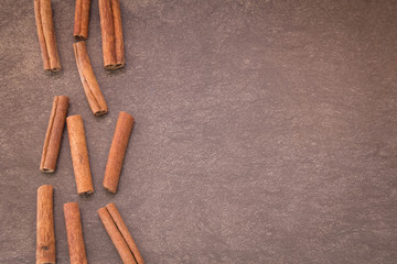 Cinnamon sticks on light brown background