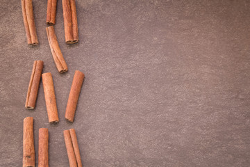 Cinnamon sticks on light brown background
