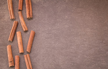 Cinnamon sticks on light brown background