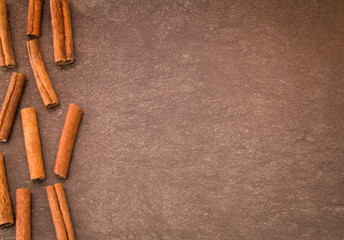 Cinnamon sticks on light brown background