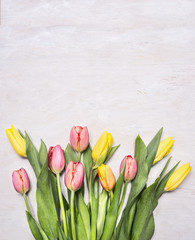 bouquet of colorful spring tulips on wooden rustic background top view close up border ,place for text