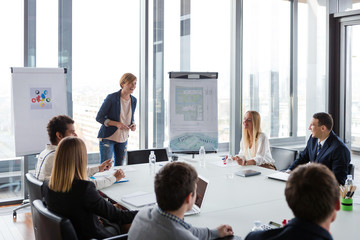 Business people laughing at meeting in modern office.