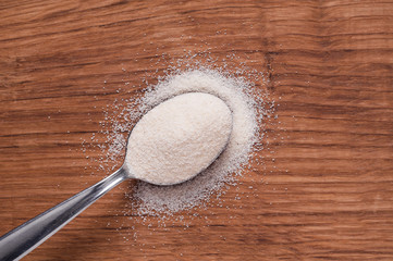 semolina on metal spoon on brown wooden table