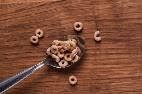 cereals on metal spoon on brown wooden table