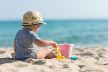 Cute baby on tropical beach playing toys - 104786644