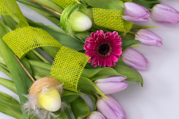 Wiosenny pastelowy bukiet z liliowych tulipanów i różowych gerber na białym tle z jutową...