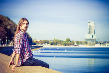 Man long hair relaxing by seaside