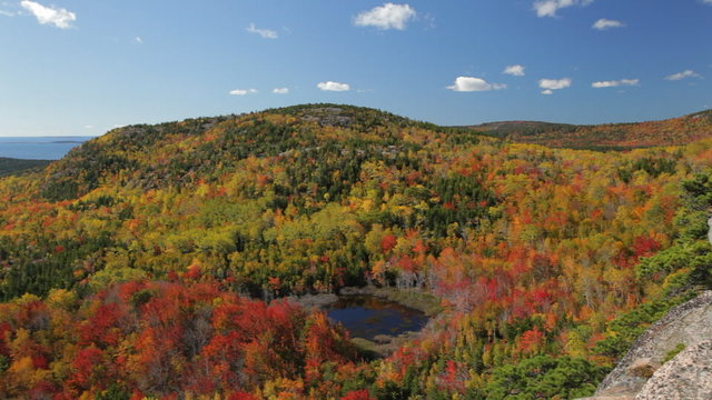 Panning view in Acadia National Park in Autumn from The Beehive. Landmarks include  Otter Point, Gorham Mountain, and Kief Pond.
