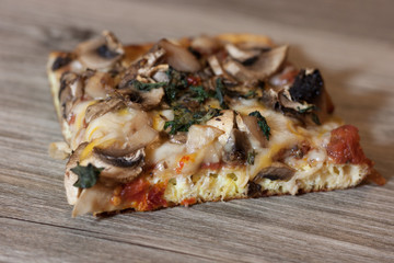 Delicious and mouth watering homemade veggie pizza with mushrooms, sun-dried tomatoes and fresh basil