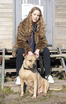 Stoere meid met hond luistert naar muziek via mobiele telefoon