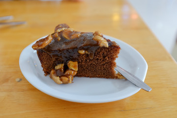 Toffee cake with cashew nuts in white plate