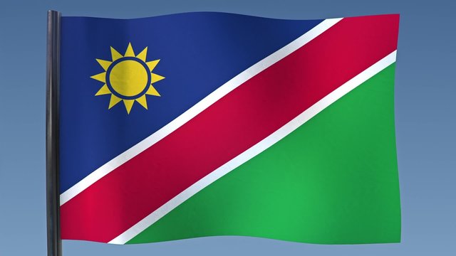 Looping flag of Namibia with a background of clear blue sky.