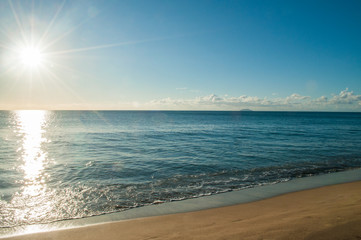 Fototapeta na wymiar Beams of sunlight in the morning at the beach