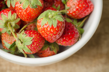 Fresh strawberry in the bowl on wooden background