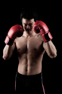 Muscular Asian man with red boxing glove