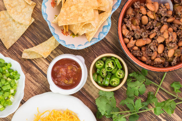 Ingredients for homemade nachos. Bowl with mixed beef and pinto beans.