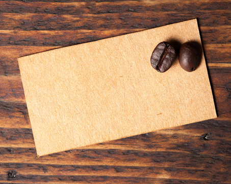 Coffee beans and paper note for text on wooden table