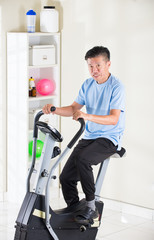 matured asian male on exercise bike