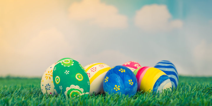 Easter Eggs on Fresh Green Grass over blue sky ( Filtered image