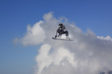 Flying snowboarder on mountains. Extreme sport.