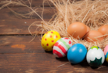 Easter eggs and hay on wooden background