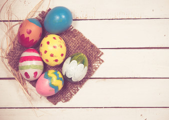 Fototapeta na wymiar Easter eggs and hay on wooden background