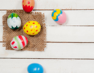 Easter eggs and hay on wooden background