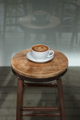 The cup of coffee costing on a wooden little table, a cappuccino, coffee with milk, fragrant a cappuccino