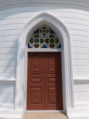 Gothic wooden church door with colorful glass