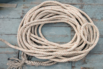 Marine rope coil on aged wooden boat. Top view
