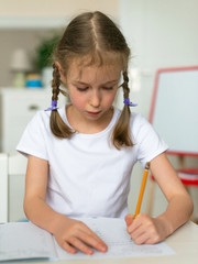 Cute little girl doing her homework for school.