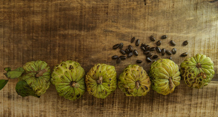 Ripe Sugar-apple Seeds by Unbroken Fruits on Wooden Table