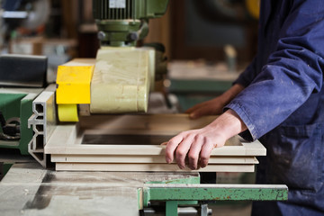 Carpenter's hands cutting wooden window frame - 104808075