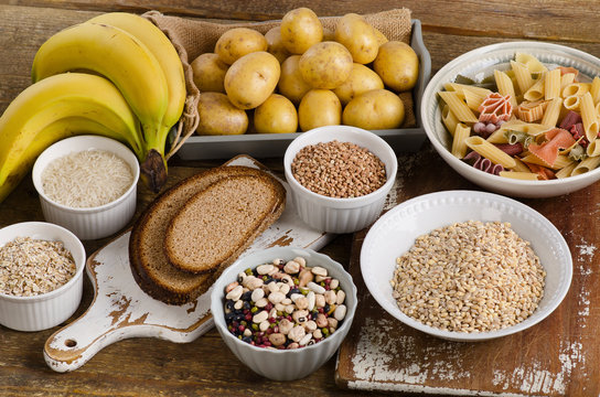Foods high in carbohydrate on a wooden background.