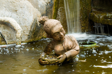 Fototapeta na wymiar Stone statue woman swim in the pool.