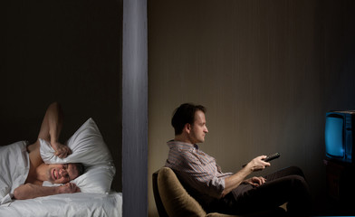 Man at night can't fall asleep because of the noisy neighbor
