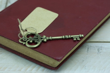 Old keys and book on a rustic background